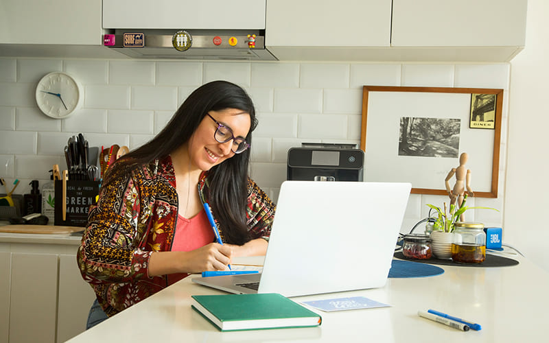 mujer joven con su laptop pensando en ideas innovadoras